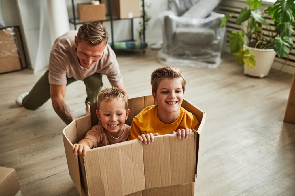 Father Playing with Sons in New House