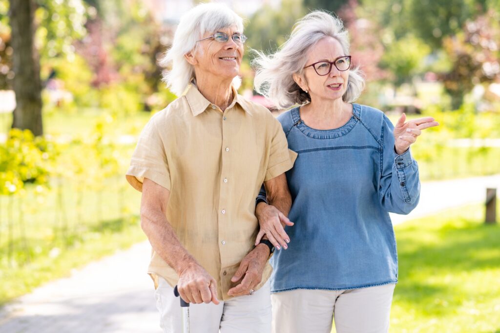 Senior couple with disability walking at the park